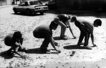 أطفال يلتقطون رصاصات فارغة من أرض المعارك في الضاحية بعد إشتباكات الحزب والحركة 27-5-1988